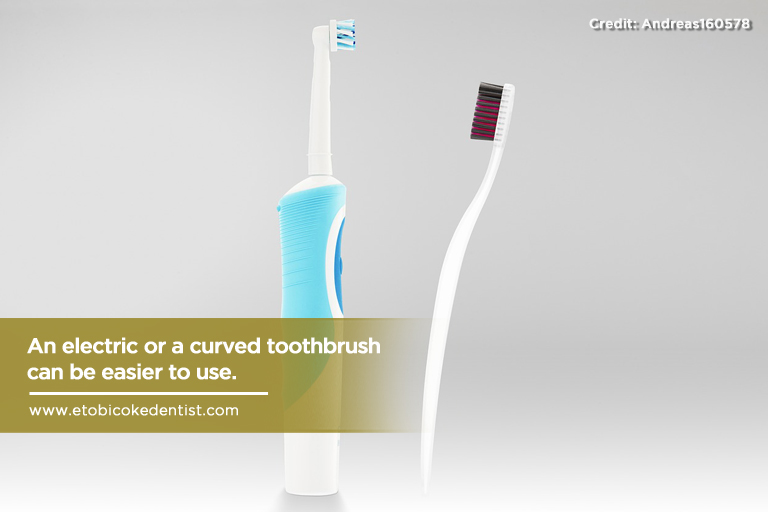 An electric or a curved toothbrush can be easier to use